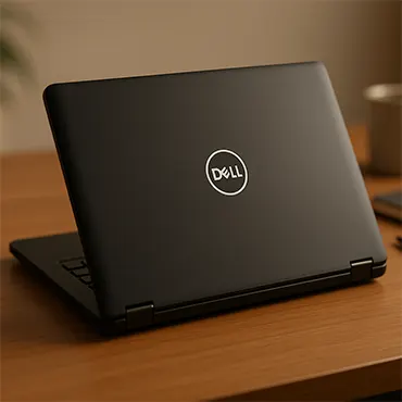 Laptop Dell Latitude E7270 đóng nắp đặt trên bàn gỗ trong không gian văn phòng hiện đại, logo Dell hiển thị rõ.